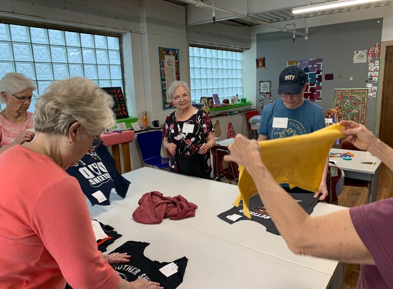 Women laying out a tshirt quilt