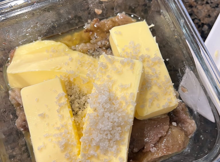 Container with roasted bone marrow, softened butter, and unrefined salt ready to be mixed
