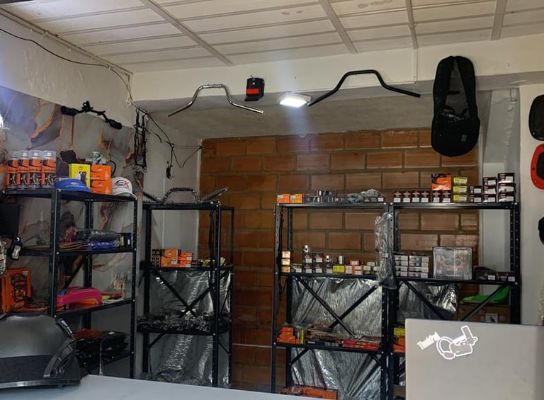 Tienda de repuestos para motocicletas con estanterías llenas de accesorios,manillares y equipamiento