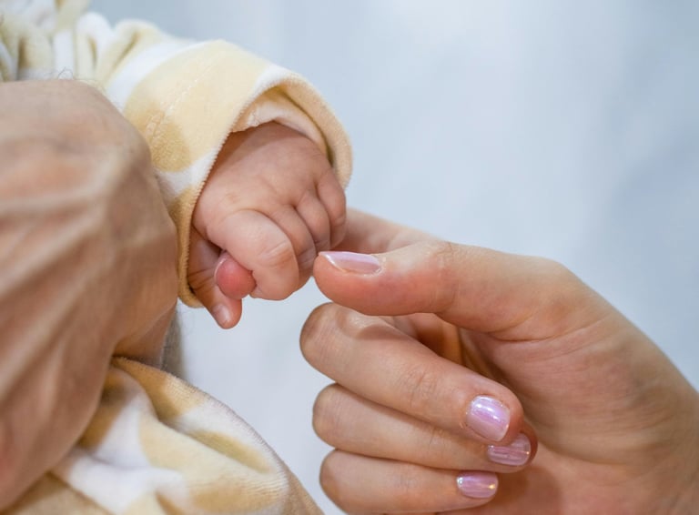 a baby's hand holding a baby's finger