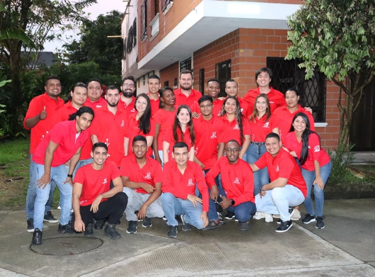 a group of people in red shirts and jeans posing for a group photo