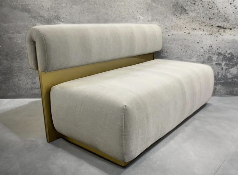 Modern bench with plush cream cushions and gold metal back, by Solo Home Decor.