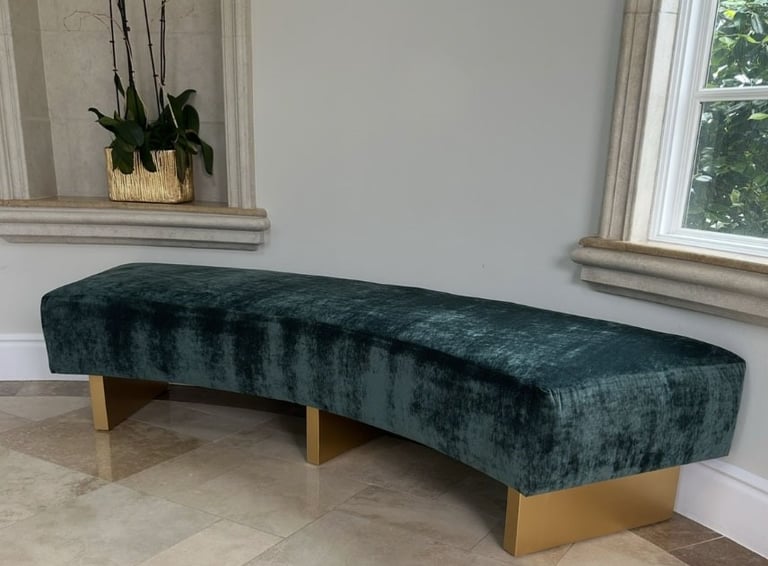 Custom curved bench with emerald green velvet upholstery and gold-painted wooden legs, handcrafted by Solo Home Decor.