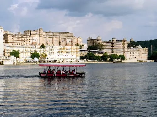 Boat ride on Lake Pichhola with City Palace Udaipur in the background.