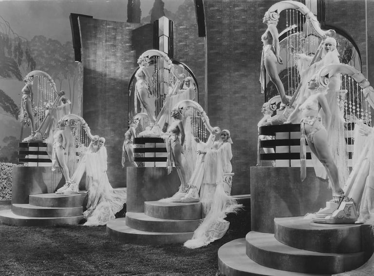 Three standing oversized harp props made of live women in a surreal Busby Berkeley musical number.