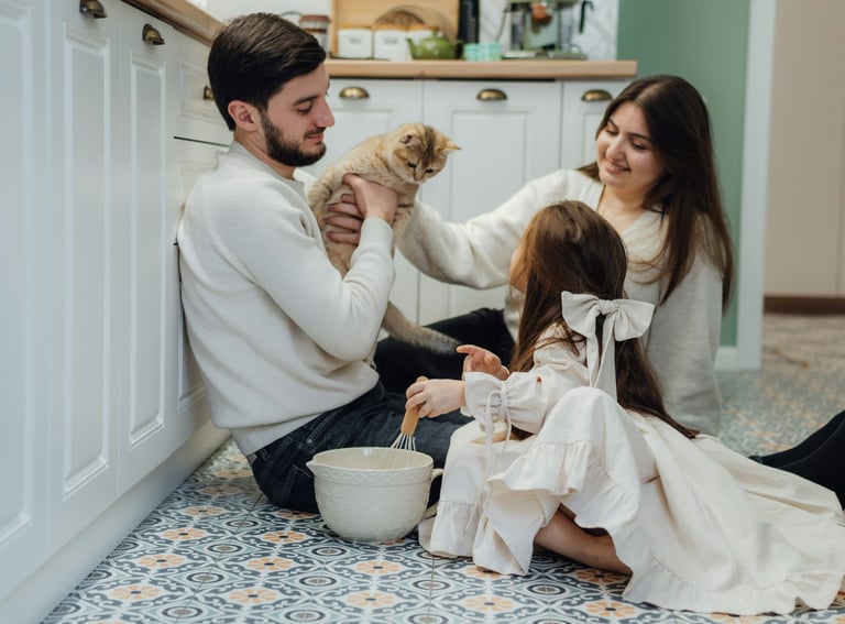 family relaxing together on the sofa in a bright, tidy living room with soft light