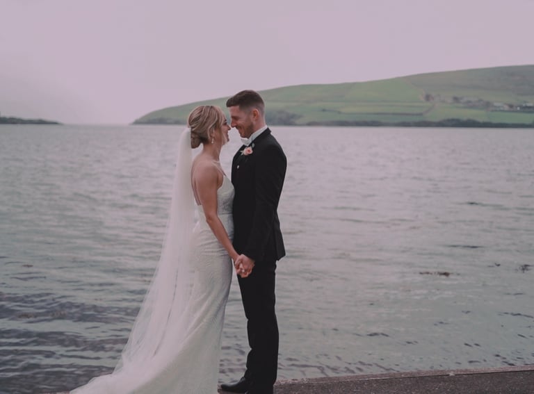 a bride and groom standing on a pier