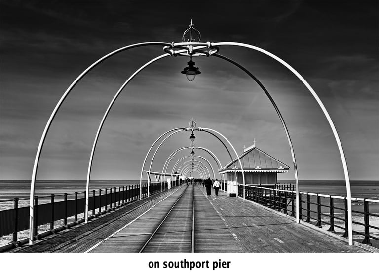 two people walking on southport pier