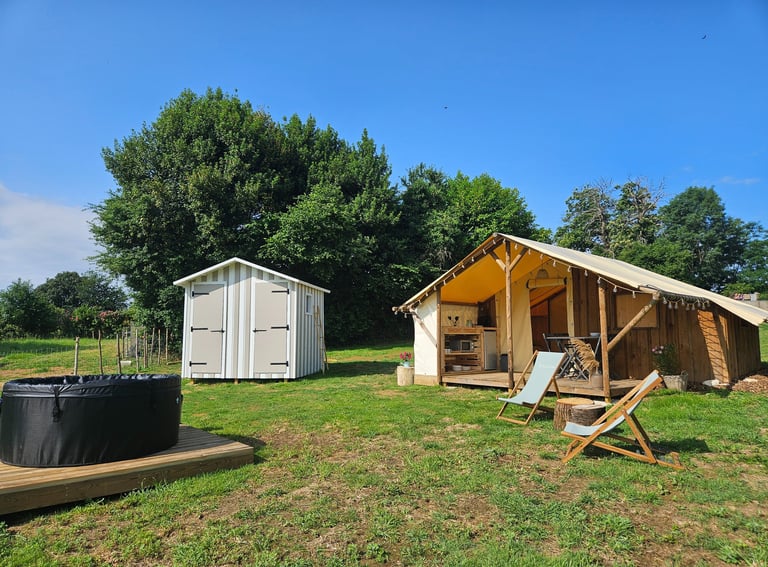 a tented out in a field with a hot tub and a hot tub