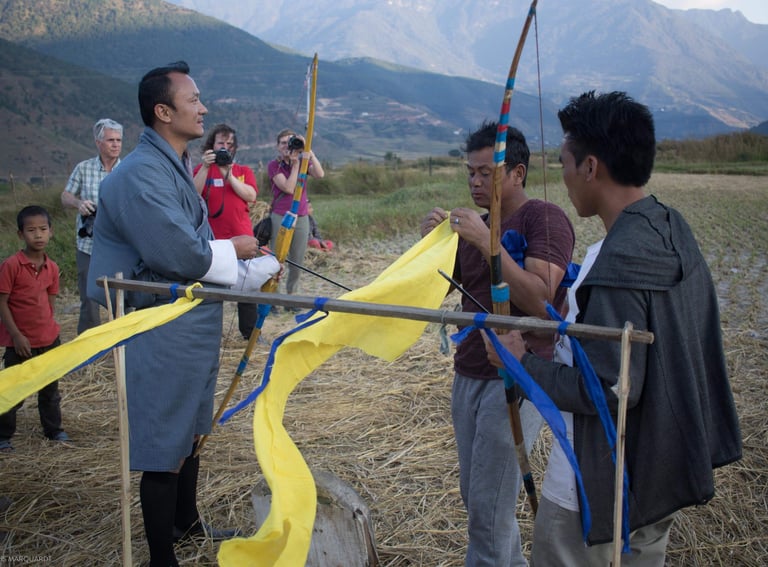 drukyul-delights-ceo-putting-demo-on-traditional-archery-to-his-group-getting-photographs