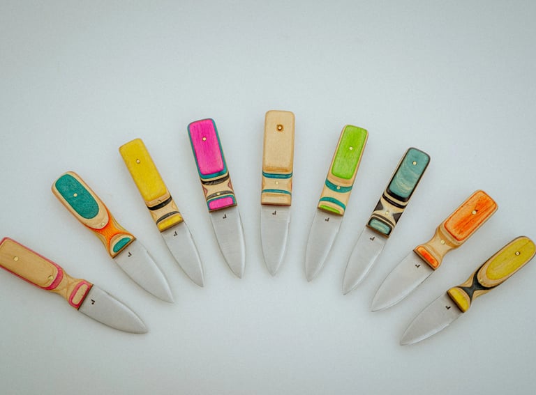 Collection of colorful handmade Oyster Knives with vibrant handles made of recycled Skateboards wood
