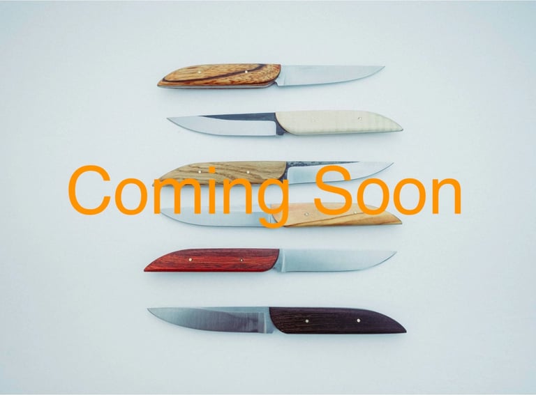 Sereral table knives handcrafted in carbon steel on a white background
