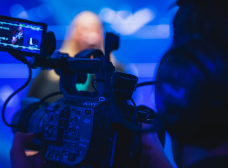 Professional videographer filming a live performance with a Sony 4K digital cinema camera.