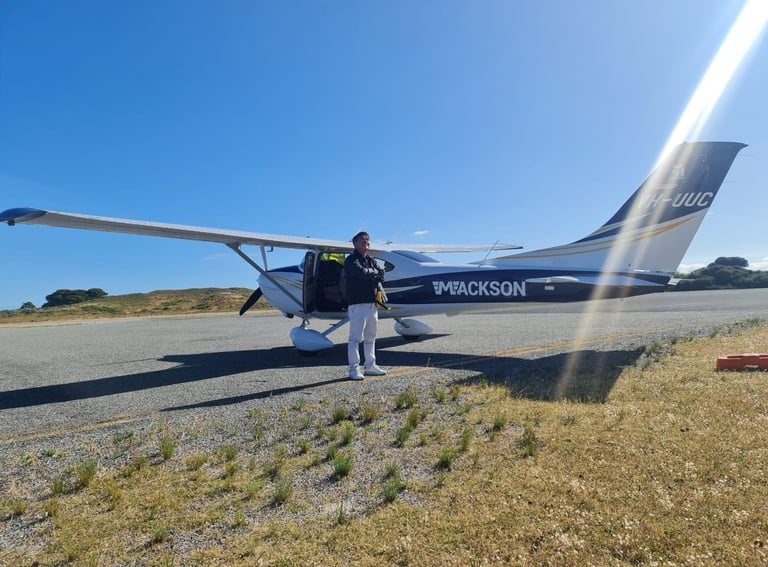 a man standing in front of a small plane