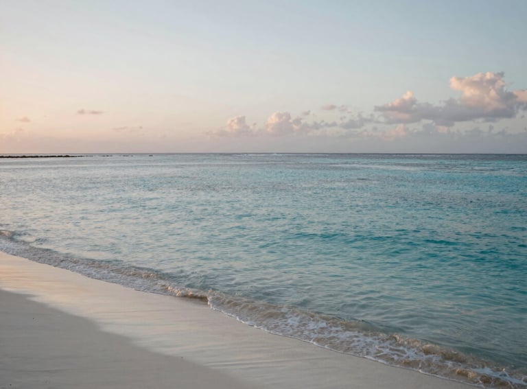 A peaceful coastline in the Caribbean / Anglophone Caribbean at dawn, with calm turquoise waters and soft white sand. The lighting is gentle and serene, emphasizing a sense of tranquility and restoration.