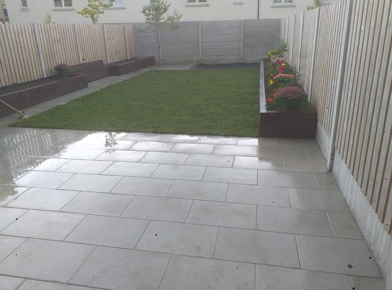 a backyard patio with a large lawn and a fenced in area