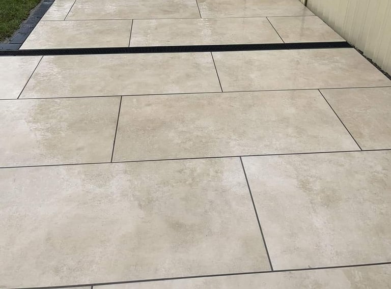 a patio with a white tile floor and a fenced in area