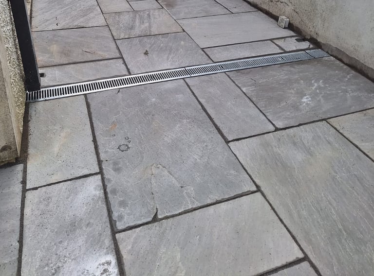 a tiled floor with a drain in the middle of the floor