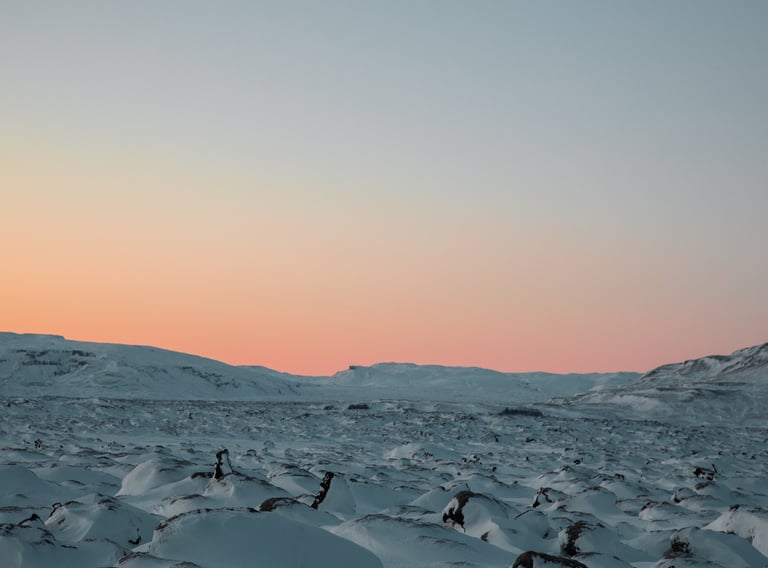 a snow covered mountain with a pink sky