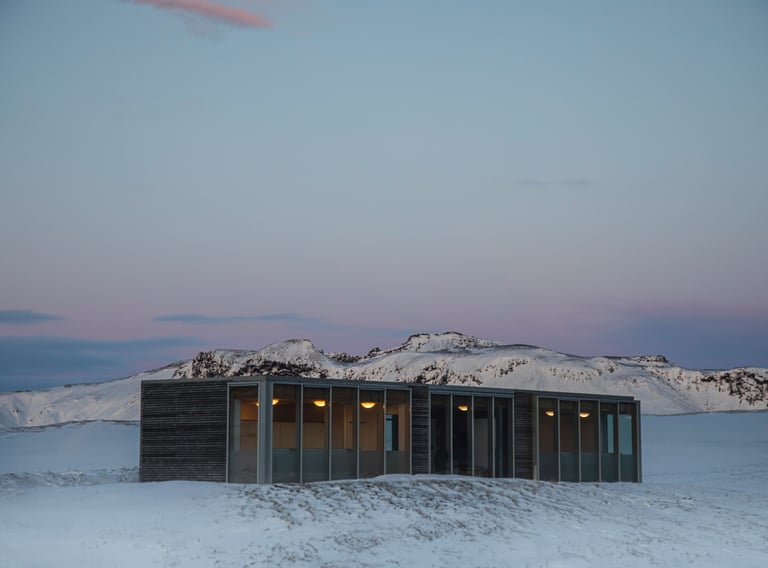 a small cabin with a view of mountains in the distance