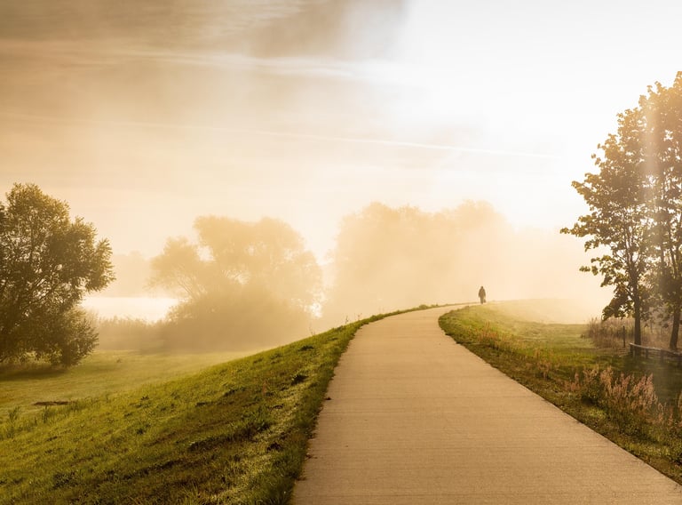 Une silhouette sur une route eclairée par le soleil du matin