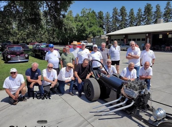 Visalia Vapor Trailers Car club members posing with the club tribute dragster