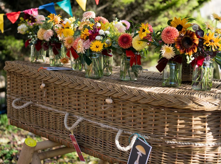 Wicker funeral casket decorated with fresh flowers