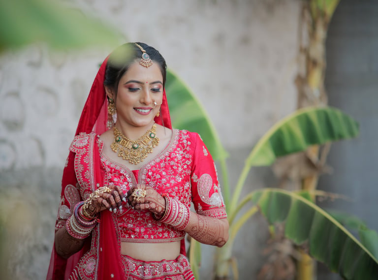 “Bridal portrait of Indian bride in red choli with gold jewellery and mehendi – wedding photography