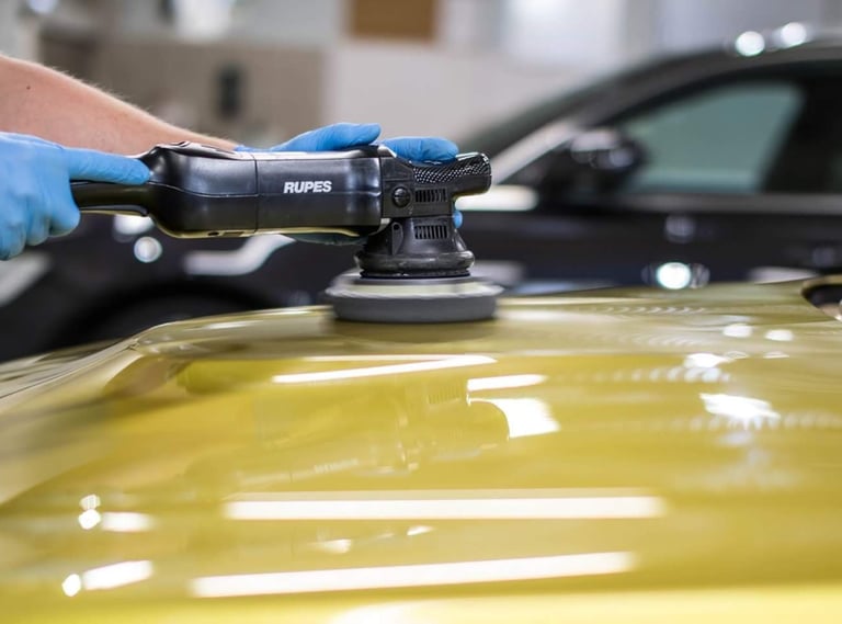 a person in gloves and polishing a car