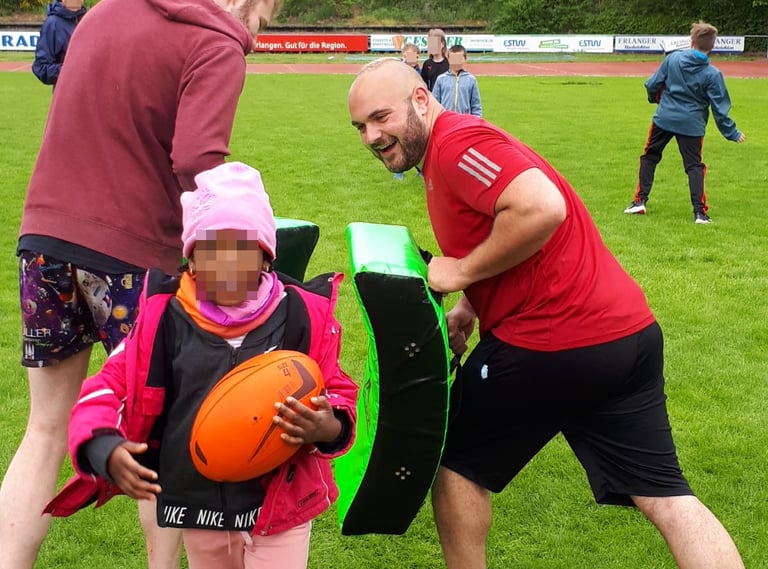 a man and a little girl learning the basics of rugby