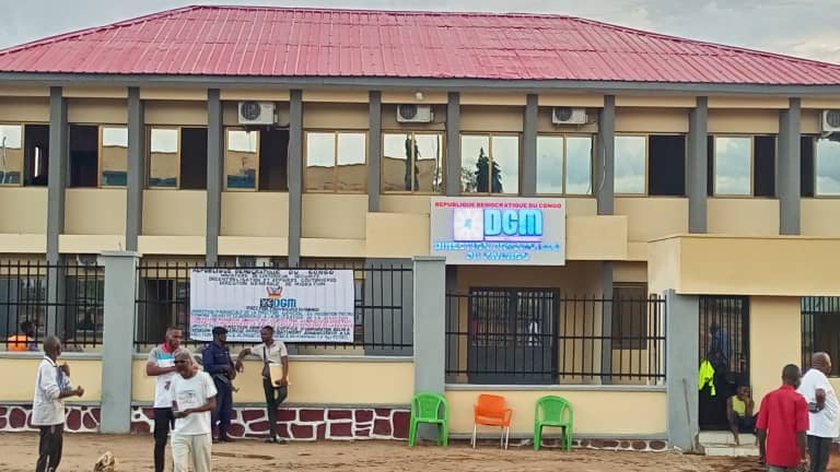 a group of people standing in front of DGM's building