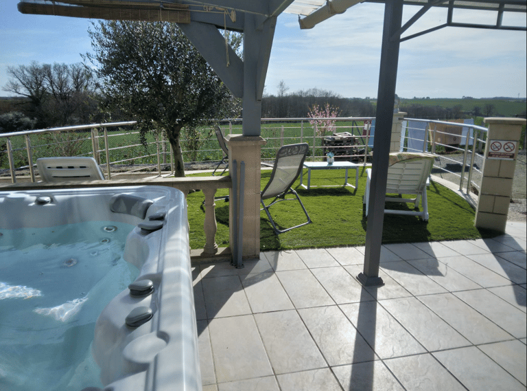 a hot tub in a backyard with a patio table and chairs