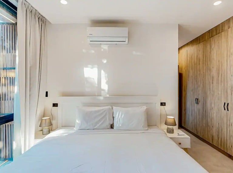a bedroom with a bed and a large window