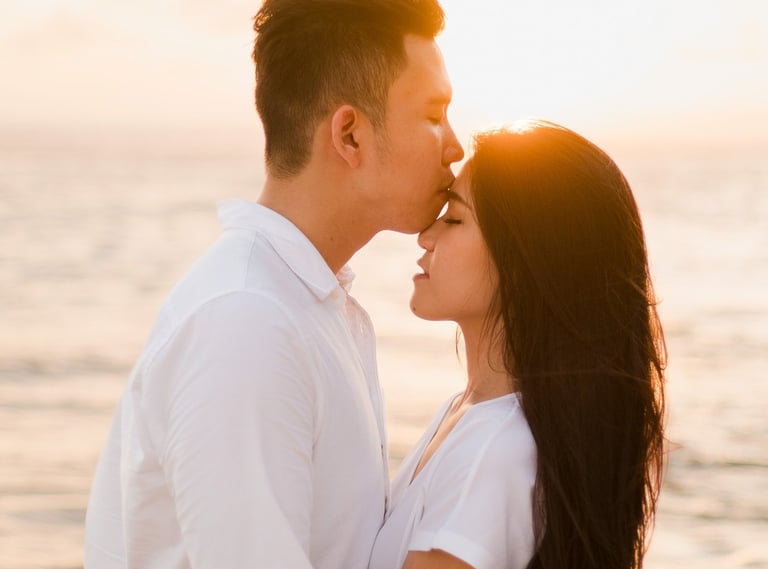 Couple embracing during sunset after proposal at Melasti Beach Bali