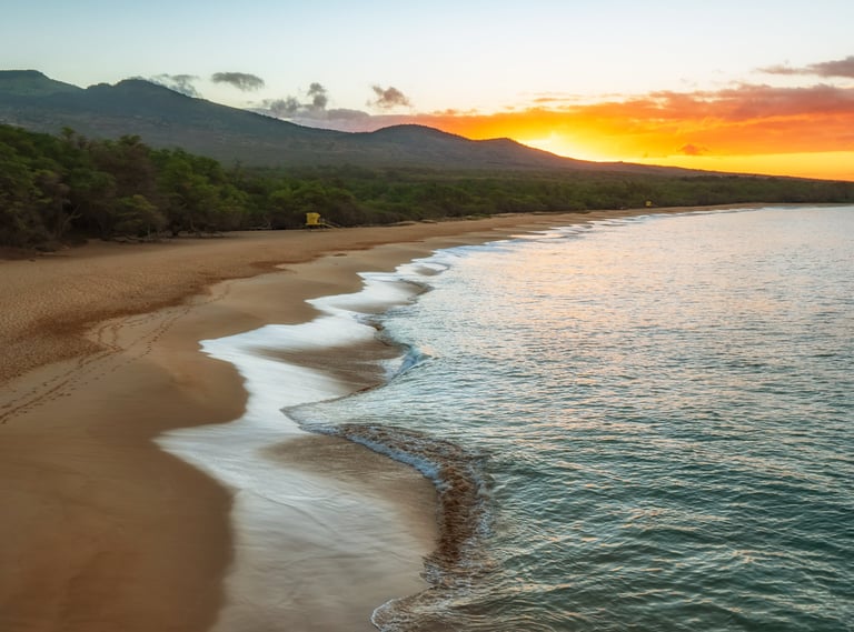a beach with a sunset in the background