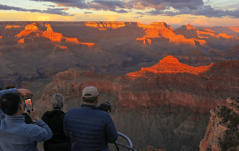 Tourist at Grand Canyon North Rim at Sunset