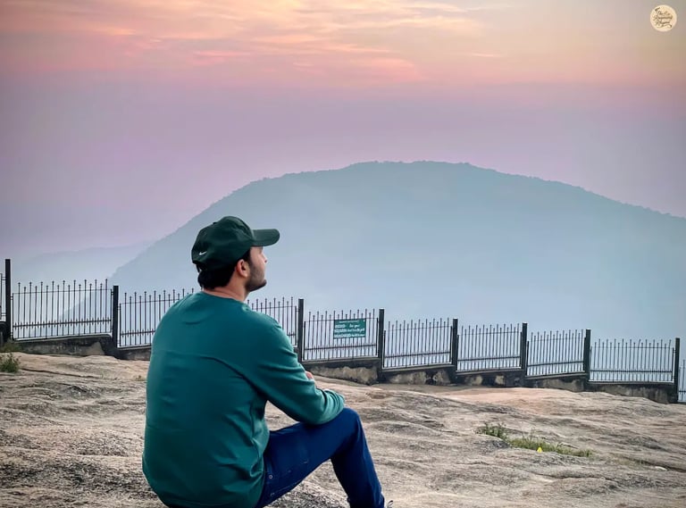 Orange, pink, and reddish sky during sunrise from the rocky terrain of Tipu’s Drop at Nandi Hills, Karnataka