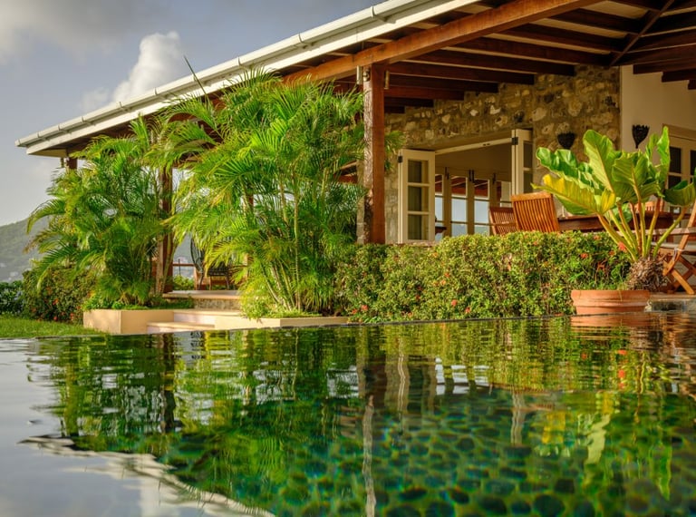 Tiled infinity pool, set among tropical gardens and overlooking the beach