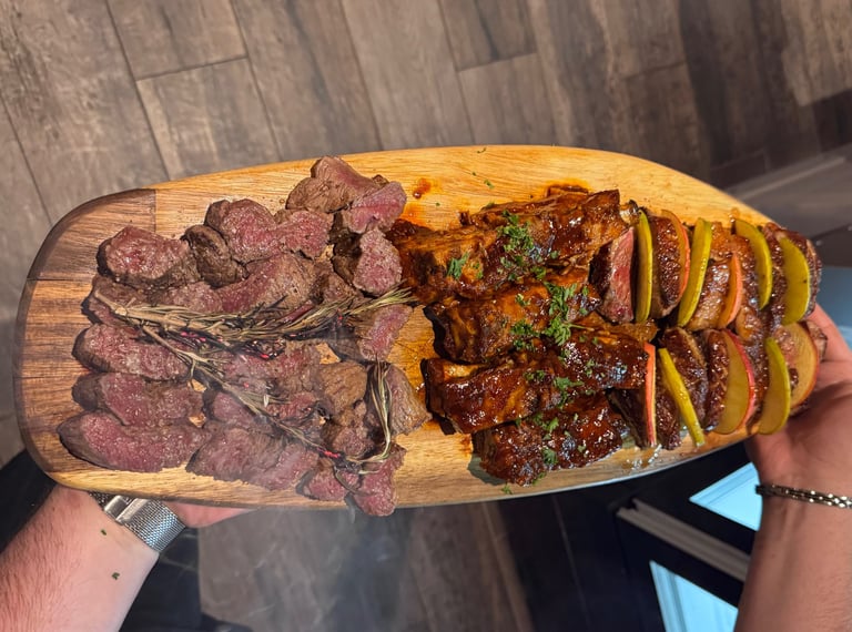 a person holding a large wooden board with steak steak and potatoes