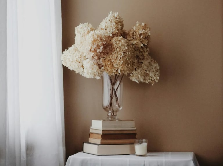 Flores secas sobre livros representando um espaço calmo e consciente de inspiração e regeneração