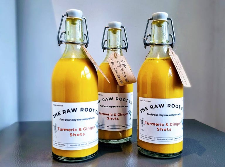 Three bottles of turmeic and ginger health and wellness shots from The Raw Root Co.