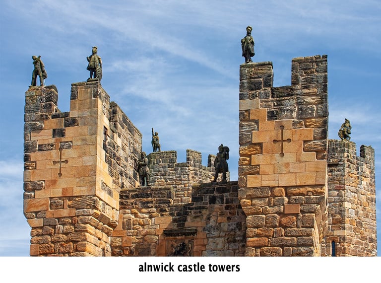 alnwick castle with statues of soldiers on top of a tower