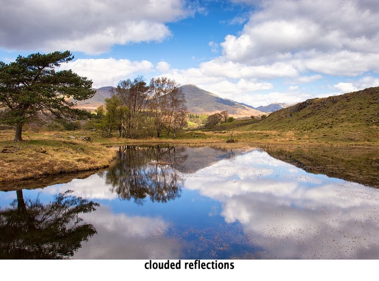 clouds and reflections in the water of kelly hall tarn lake district
