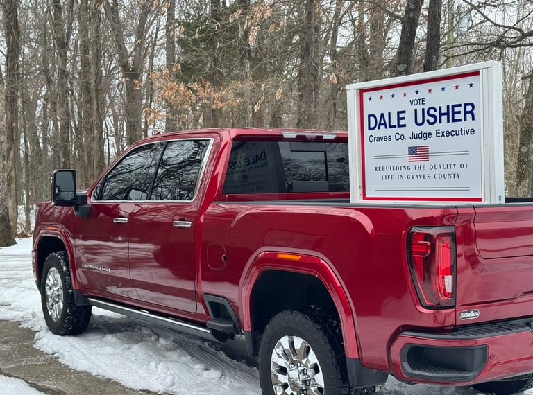 red pick-up truck with a sign in the bed saying vote, dale usher graves co. judge executive