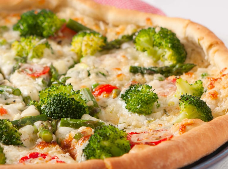 a pizza with broccoli and cheese on a plate