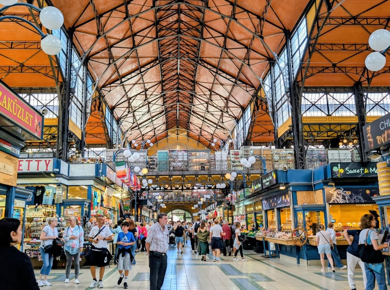 Tourists walking between the many stalls in the Central Market Hall, Budapest, Hungary.