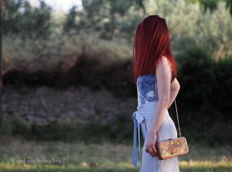 a woman in nature with elegant wooden clutch