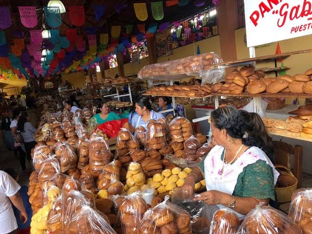 Un puesto de panadería tradicional mexicana en un mercado, repleto de pan dulce fresco y panes dulce
