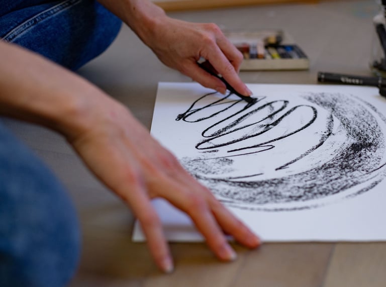 eine Person die mit Kohle auf Papier gestaltet.