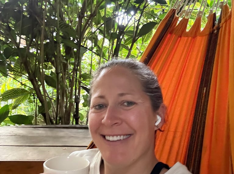 a woman in a hammock with a cup of coffee